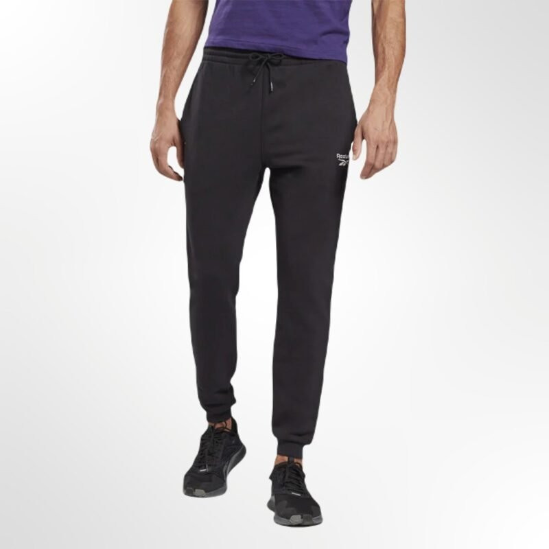 A man wearing the Reebok Identity French Terry Joggers, showcasing their comfortable, relaxed fit and modern style
